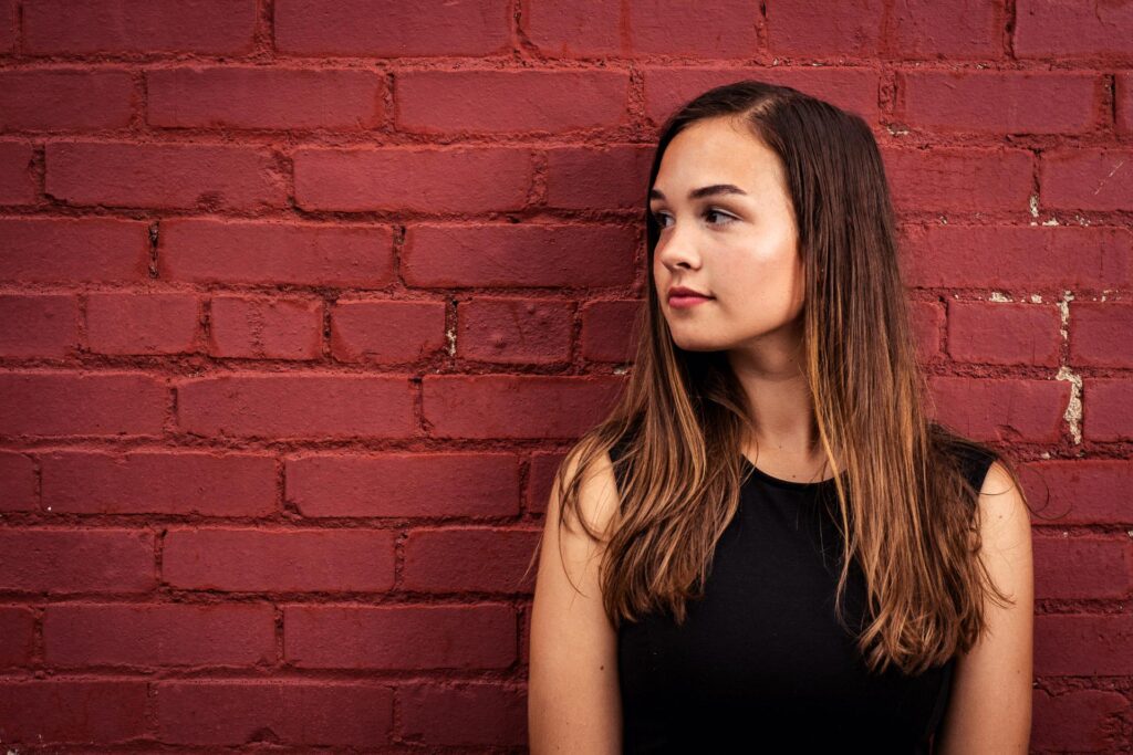 senior picture of girl in front of brick wall